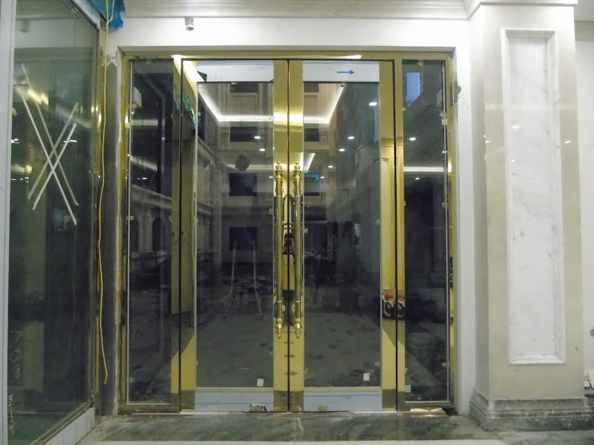 Cửa thủy lực khung bao kính inox vàng